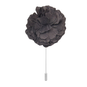 black cotton flower lapel pin on white background men’s boutonniere
